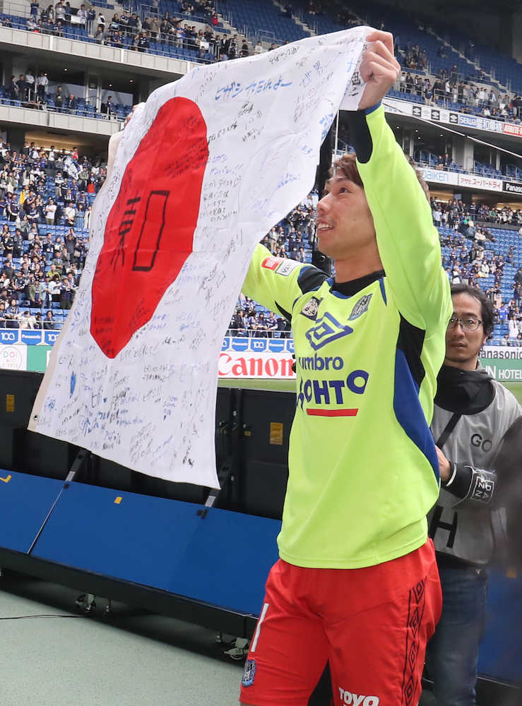 ＜Ｇ大阪・浦和＞試合後、Ｇ大阪の東口はサポーターから寄せ書き入りの日の丸を受け取る