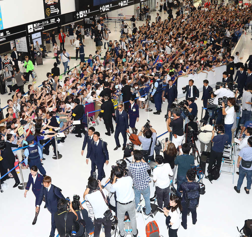大勢のファンが待ち受ける中、成田空港に到着した本田（中央）ら日本代表イレブン（撮影・三島　英忠）