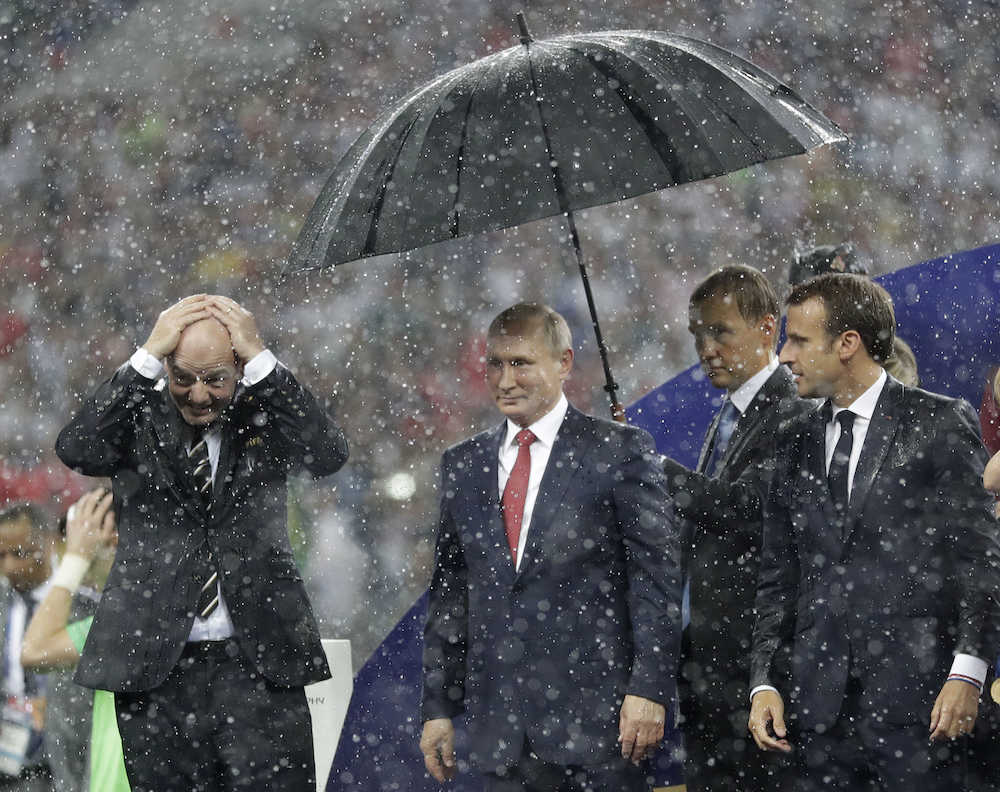 傘で雨に濡れるのを避けたロシアのプーチン大統領（ＡＰ）