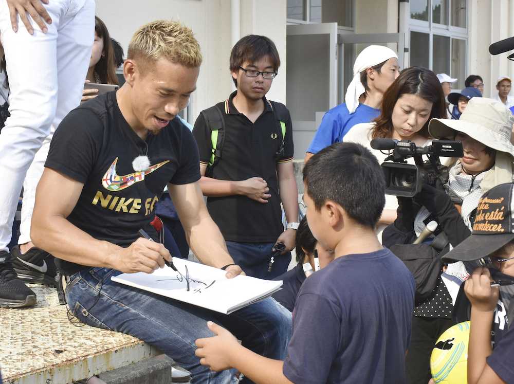愛媛県大洲市で小学校を訪問し、児童らにサインする長友