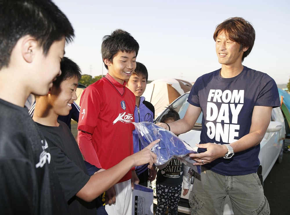１６年５月、熊本地震の被災地支援でサポーターの子供たちにユニホームを贈る