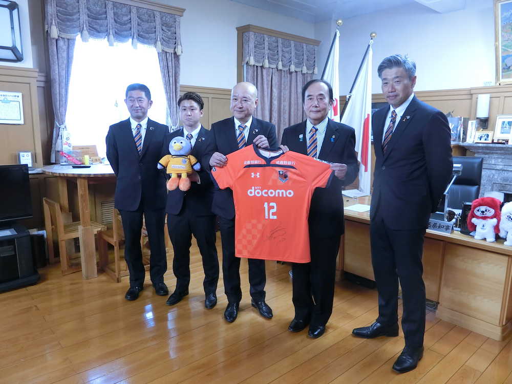 上田埼玉県知事（右から２人目）にユニホームのレプリカをプレゼントした大宮の森社長（中央）。右端は高木監督、左から２人目は大前