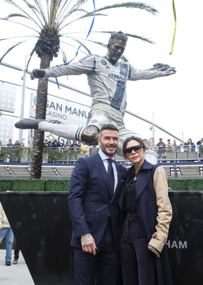 銅像の前で記念撮影する元イングランド代表のベッカム氏とビクトリア夫人（ＡＰ）