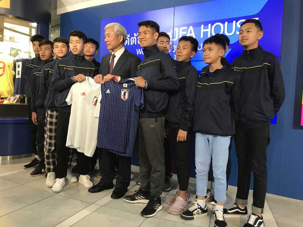 タイの洞窟で救出されたサッカーチームの少年らが文京区のサッカーミュージアムを訪問。大仁邦弥館長（中央）から記念品として代表ユニを贈呈された