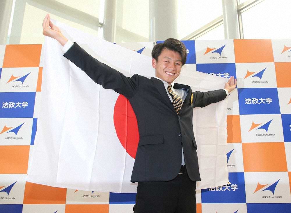 南米選手権・日本代表メンバーに選出された法大・上田が日の丸を手に笑顔を見せる（撮影・大塚　徹）