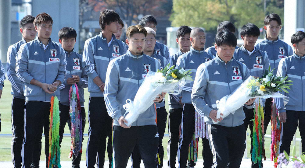 広島平和記念公園を訪れ、チームを代表して献花する中山（手前・左）と横内コーチ（後方左から3人目が久保）（撮影・成瀬　徹）　　　　　　