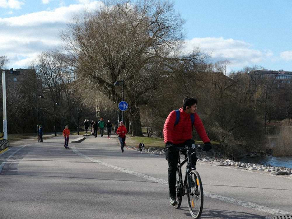 自然あふれる場所をサイクリングや散歩をする人々（撮影・田中　亜土夢）