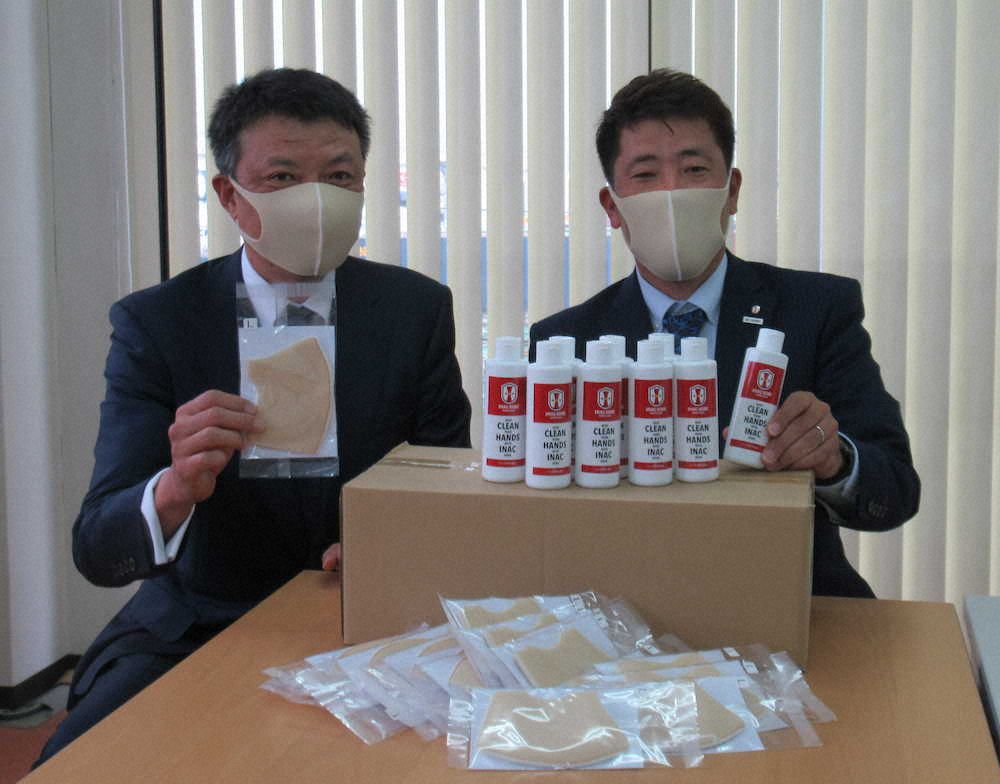 医療従事者の無料送迎をするMKタクシーの青木代表取締役（左）にマスクなどを寄贈するINAC神戸の安本社長