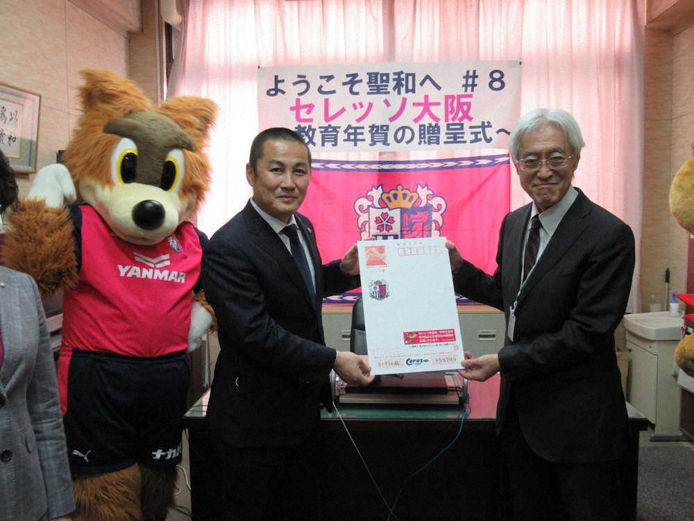 “巨大年賀状”を手に撮影に応じるC大阪の森島社長（左）と聖和小の久保校長