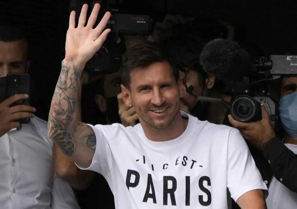 PSGのスローガン入りのTシャツを着てパリ郊外のル・ブルジェ空港に到着し、ファンに手を振るメッシ（AP）