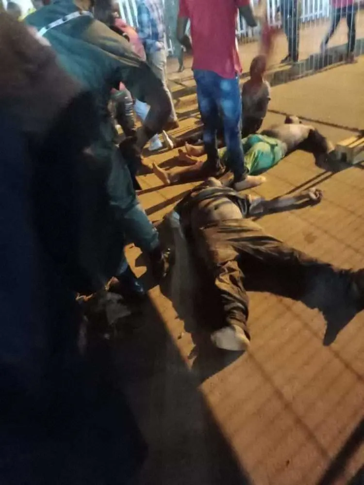 オレンベ・スタジアムの外で負傷者を介抱する人たち（AP）