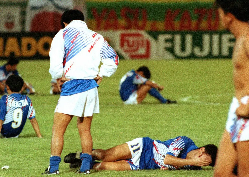 1993年10月、イラクと痛恨のドローに終わった日本は悲願のW杯初出場を逃し、三浦知良（11番）ら日本代表イレブンはピッチで泣き崩れる。この試合は「ドーハの悲劇」として日本サッカー史で語り草となっている