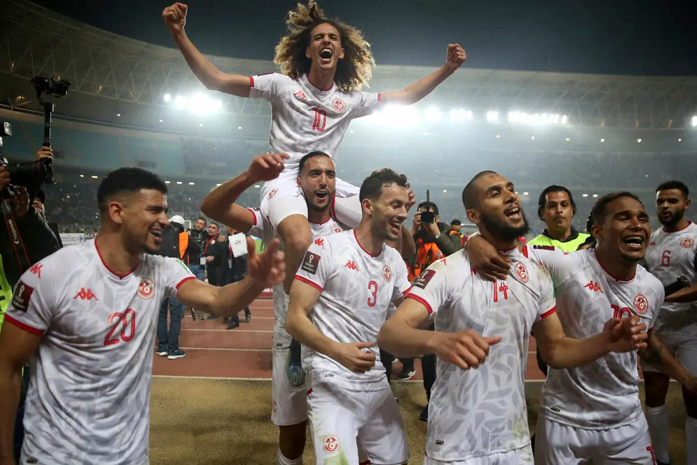 22年3月、2大会連続6回目のW杯出場を決め喜ぶチュニジア代表イレブン。左端がDFドレーガー、上で肩車されているのがマンチェスターU所属のMFメイブリ（AP）