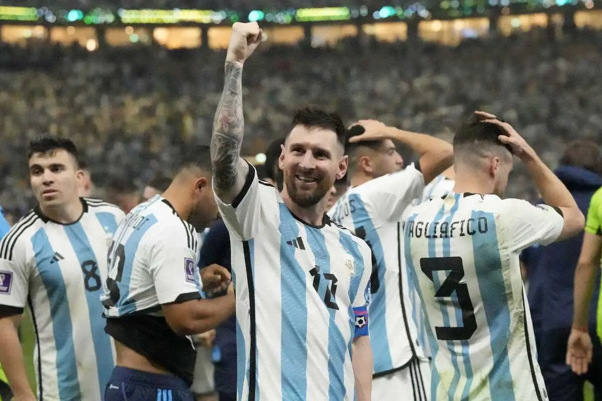 悲願のワールドカップ優勝を果たし笑顔で右腕を突き上げるアルゼンチン代表のメッシ（AP）