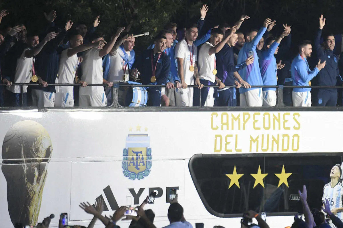 首都ブエノスアイレス郊外の空港に着陸後、バスから手を振るアルゼンチン代表の選手たち（AP）
