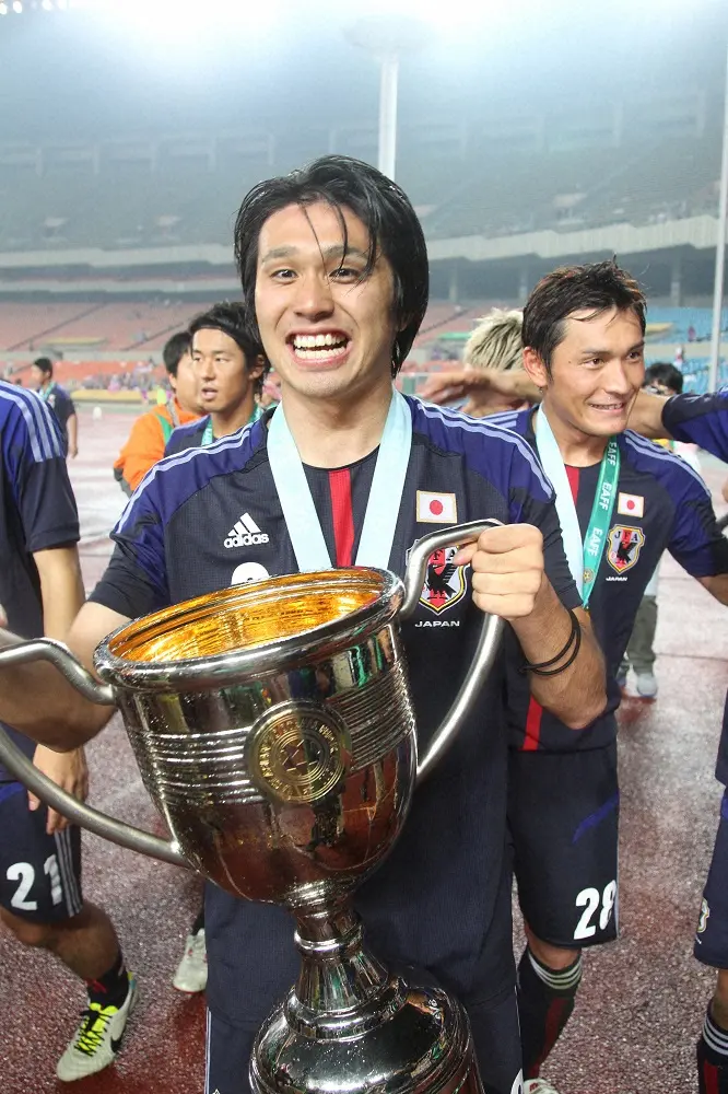 2013年、ザックジャパンで東アジアカップを制しトロフィーを手に笑顔を見せるFW工藤壮人さん