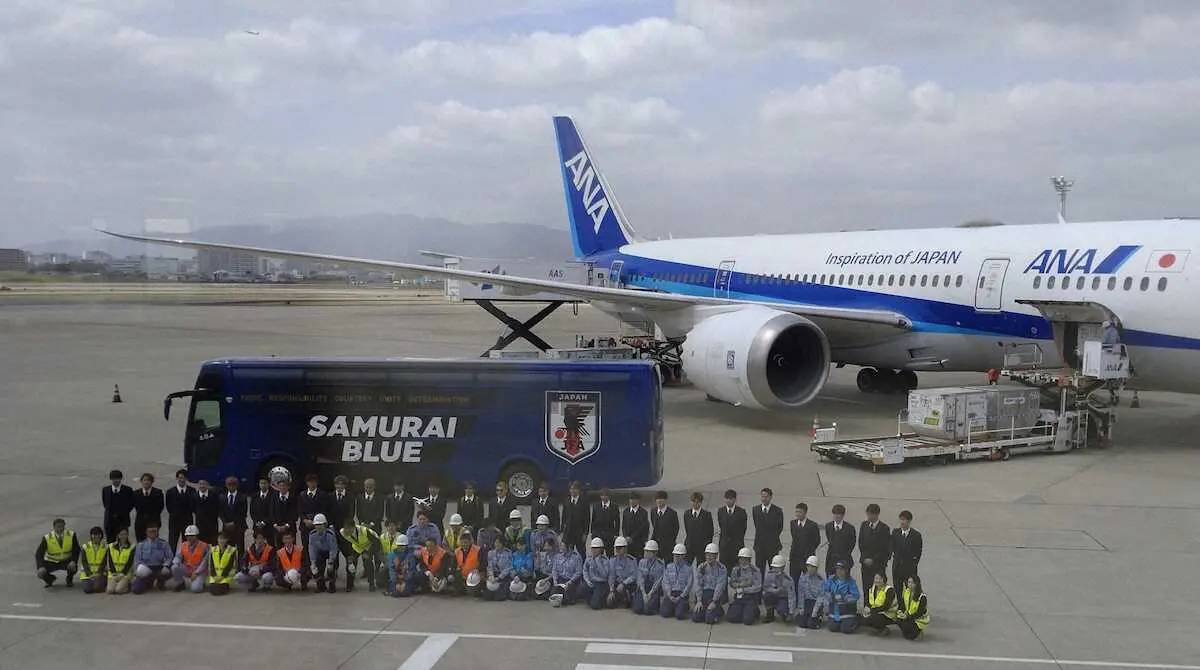 伊丹空港で機体をバックに全日本空輸株式会社の関係者と記念撮影する日本代表イレブン