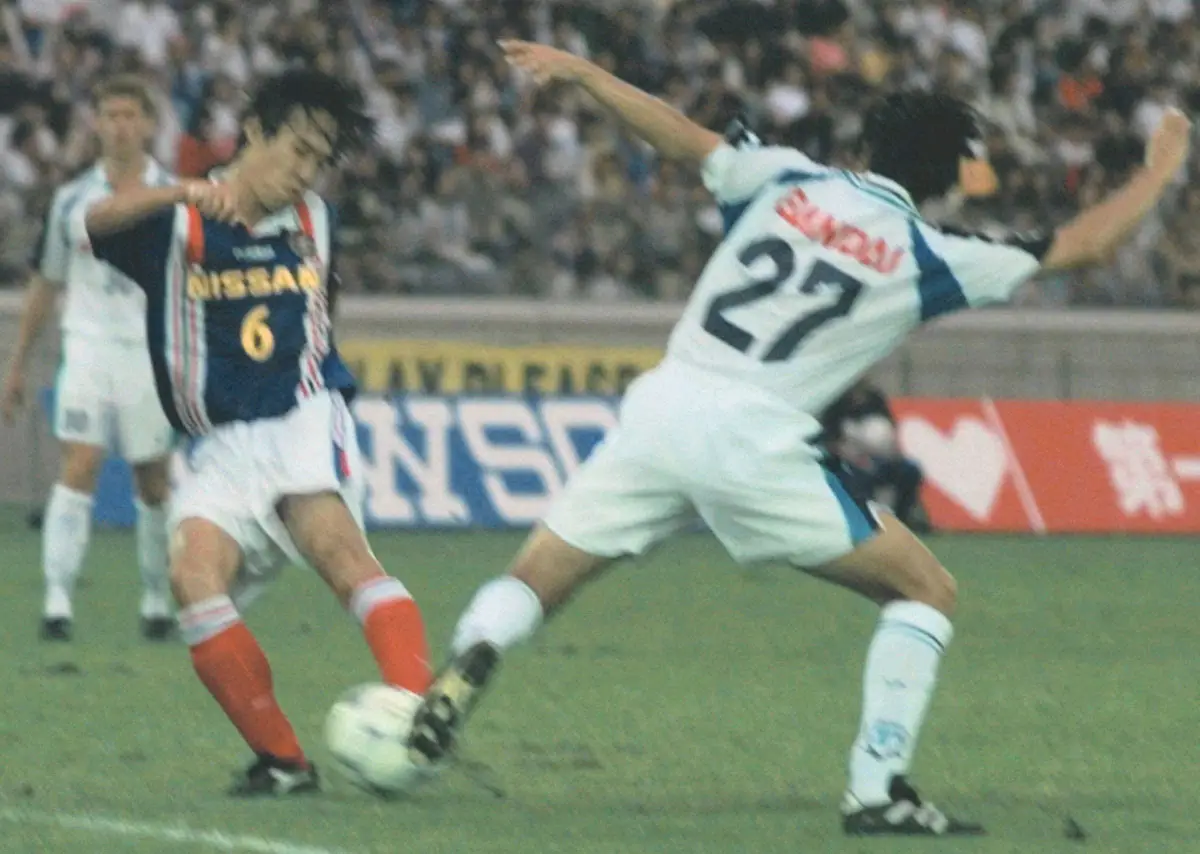 1998年、横浜マリノス・上野良治（６）が横浜フリューゲルス・遠藤保仁をかわしシュート。両チームの対戦はこれが最後に…