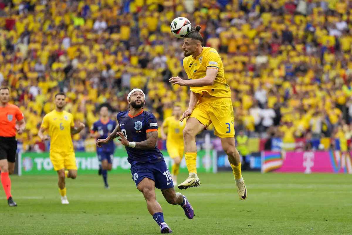 【画像・写真】＜欧州選手権　ルーマニア・オランダ＞前半、クリアするルーマニア代表ドラグシン（右）（ロイター）