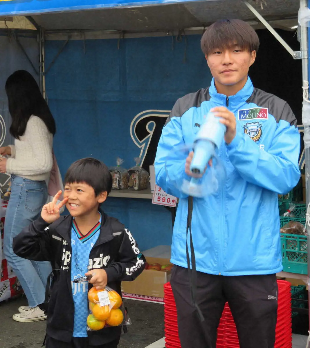 【画像・写真】ハンドマイクを手に野菜の販売に協力する由井