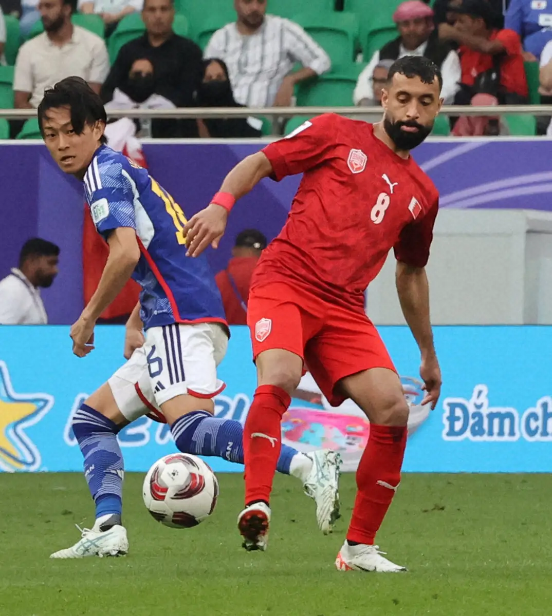 【画像・写真】24年1月のアジア杯カタール大会決勝トーナメント１回戦、日本代表・毎熊（左）と競り合うバーレーン代表FWマルフーン