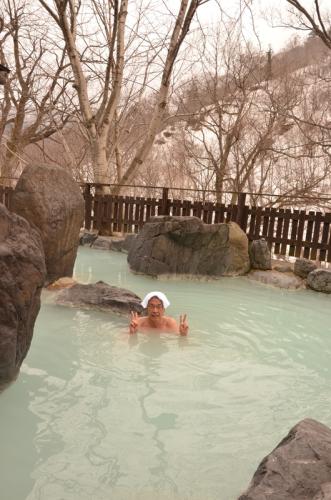松川温泉・峡雲荘の白濁色の露天風呂。あまりの心地よさに観光客もＶサイン