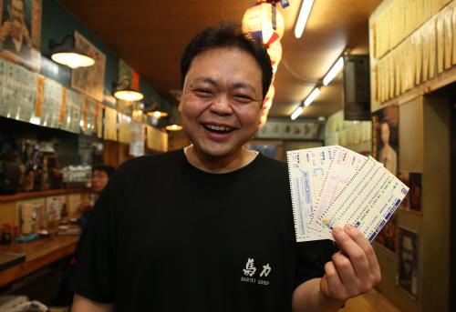 投票カードを手に笑顔を見せる丸山店長