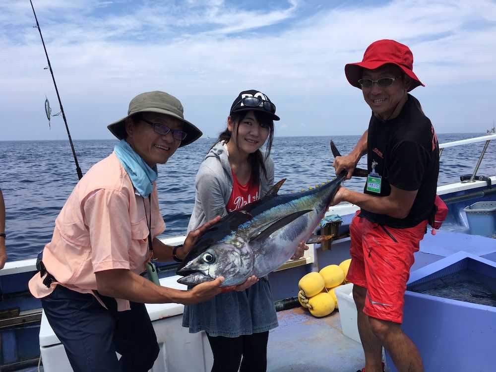 昨年夏、相模湾で中嶋政文さん（右）がペンシルで釣った２７キロのキハダ。東京海洋大学生の高橋恵里香さん（中央）も「いつか釣ってみたい」。左は筆者　