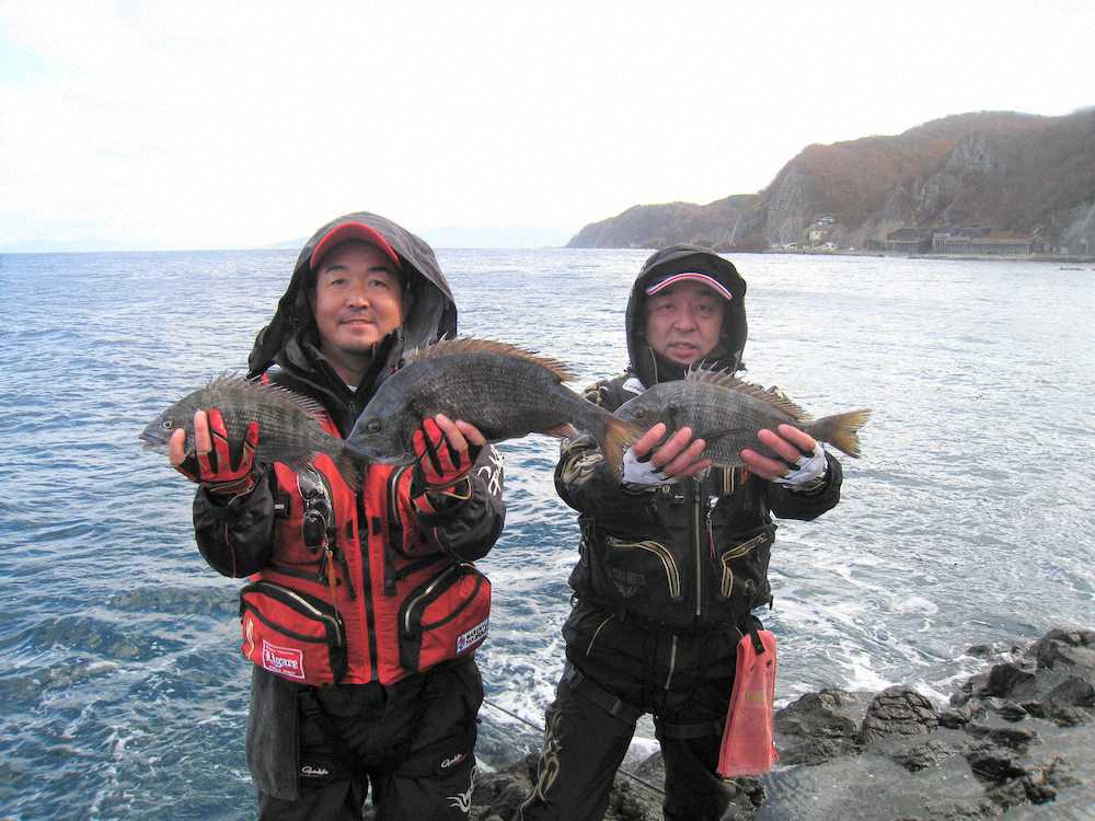 青森県の竜飛崎では、寒さで笑顔も引きつるがそろって本命を手にした（左から）一戸さんと平野さん