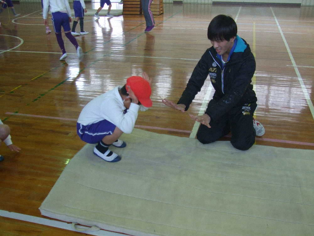 和歌山大の学生が前転のやり方をていねいに個別指導　