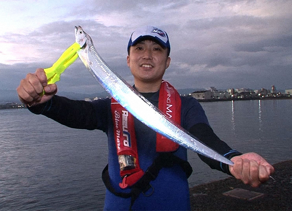 釣り上げたタチウオを手にポーズをとる大澤氏