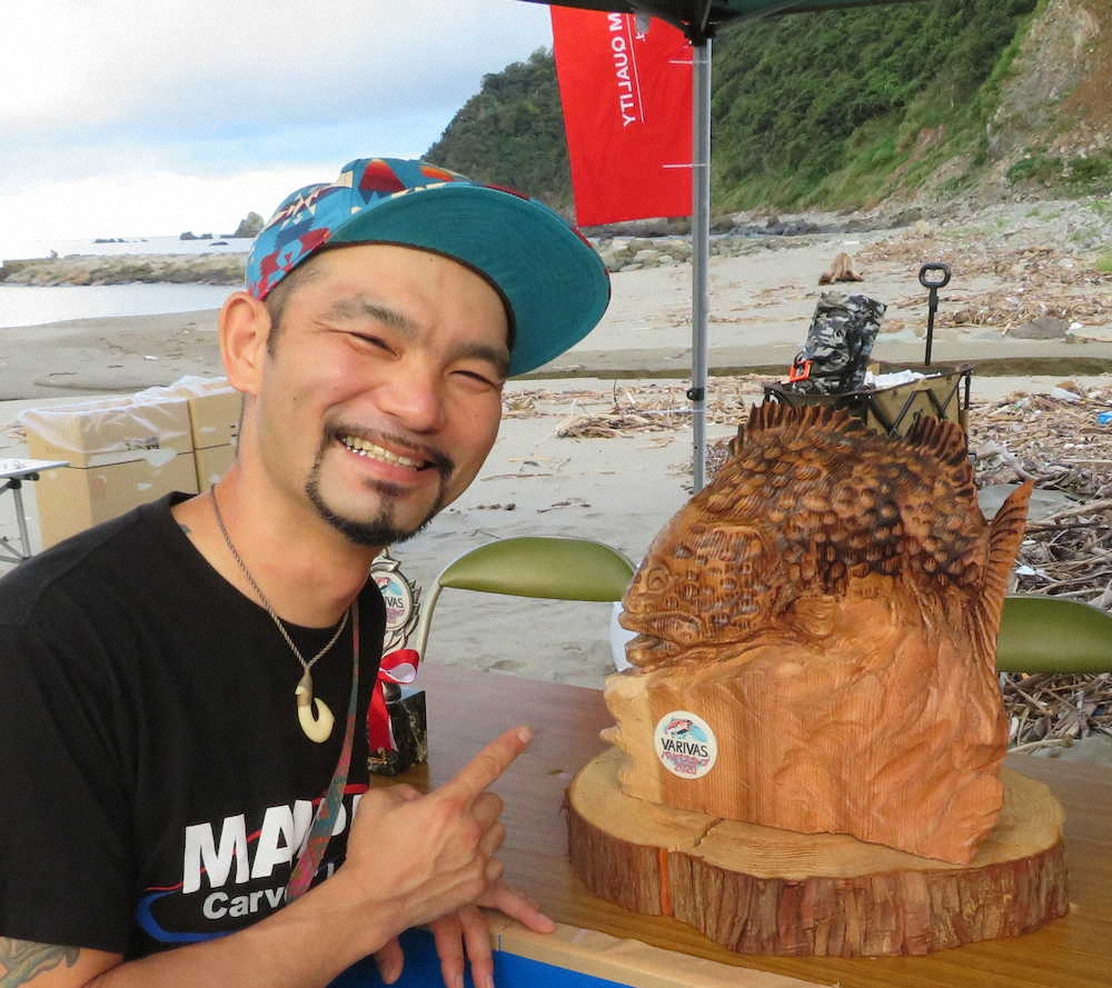 オオモンハタの木彫りトロフィーと製作者の佐藤さん　　　　　　　　　　　　　　　　　　　　　　　　　　　　　　　