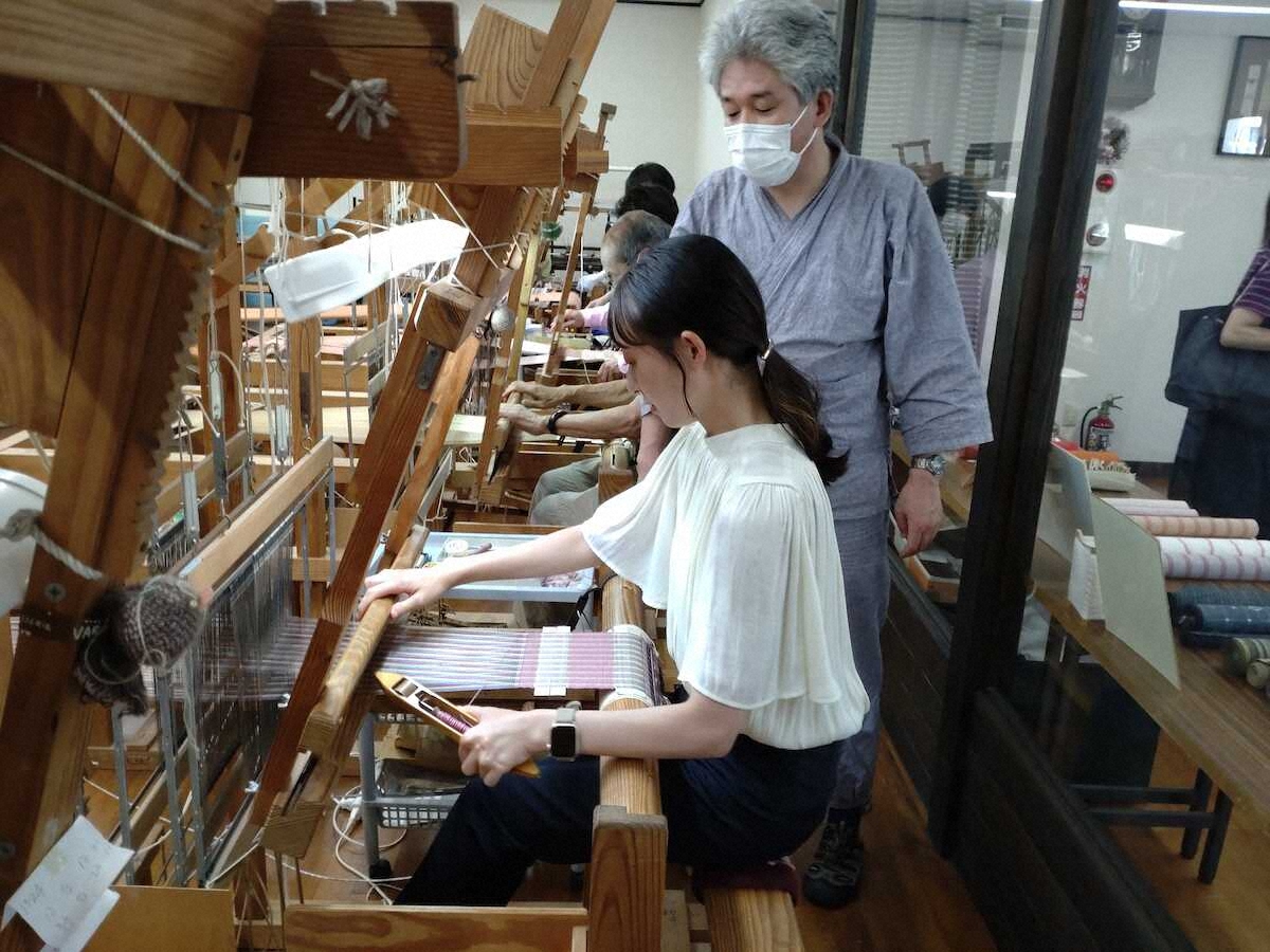 機織り体験で折り方を指導する3代目の佐藤さん（右）
