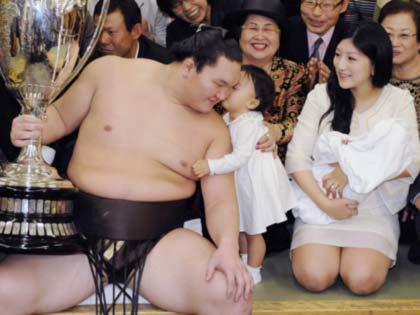 大相撲秋場所で優勝し、娘の愛美羽ちゃんの祝福を受ける白鵬。右は紗代子夫人
