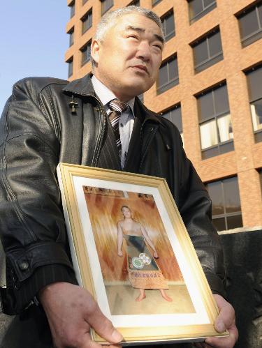 時津風部屋力士暴行死事件の元親方の初公判で、亡くなった斉藤俊さんの遺影を抱えて名古屋地裁に向かう父正人さん
