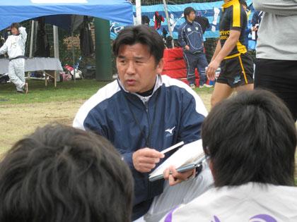 試合後に選手に反省点を説明する明大・吉田監督