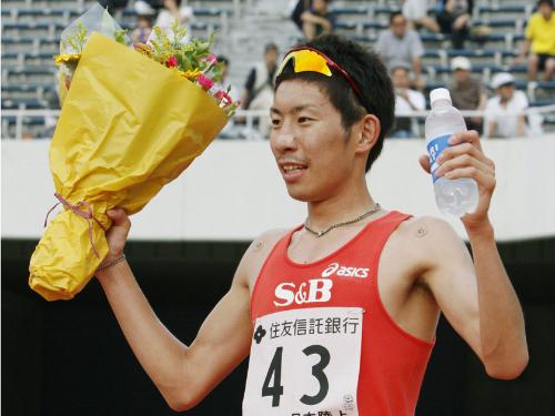 男子５０００メートルで初優勝し、花束を手に笑顔を見せる上野裕一郎