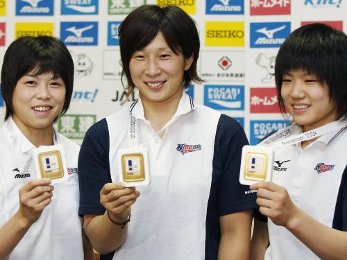 柔道の世界選手権で獲得した金メダルを手に笑顔の（左から）福見友子、上野順恵、中村美里