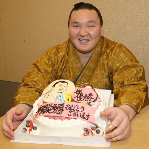 ＜大相撲九州場所・１４日目＞年間最多勝の８５勝を決め、カメラマンからの祝いのケーキを手に笑顔の白鵬