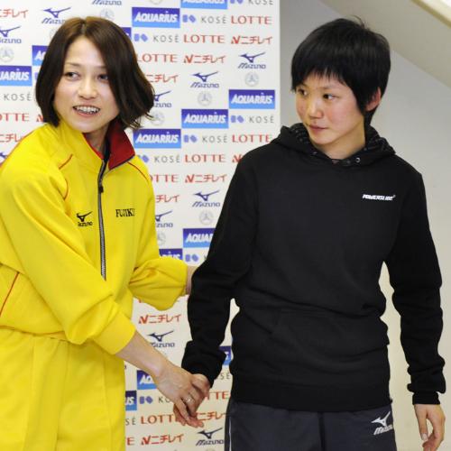 スピードスケートのバンクーバー冬季五輪代表に選ばれ、３８歳の岡崎朋美選手（左）にうながされ握手をする１５歳の高木美帆選手