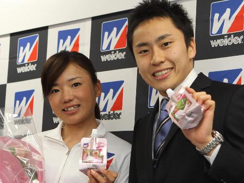 サプライズゲストとして登場した森永製菓所属・太田雄貴（右）から花束を贈られ笑顔を見せる有村智恵