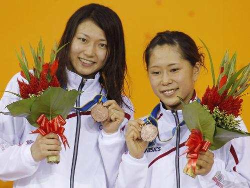 女子シンクロ板飛び込みで獲得した銅メダルを手に笑顔を見せる中川（右）、渋沢組
