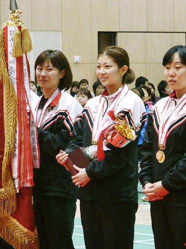 バドミントンの日本リーグ女子で優勝し、表彰式でカップを手にする日本ユニシスの潮田玲子（中央）