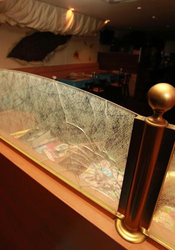 事件があった墨田区内の飲食店の店内客席の間仕切りのガラス部分は破損していた
