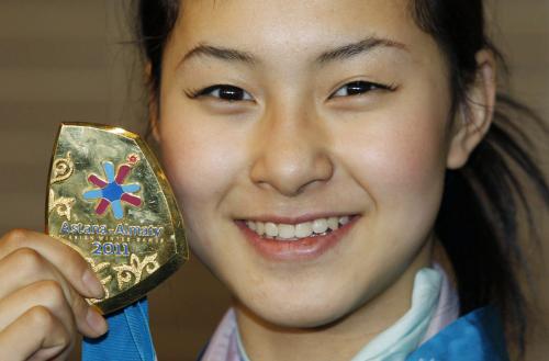 成田空港に帰国し、冬季アジア大会で獲得した金メダルを披露する村上佳菜子