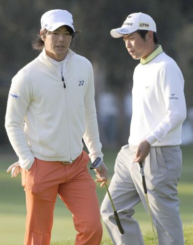 再開された第２ラウンド、９番でプレーする石川遼（左）と池田勇太