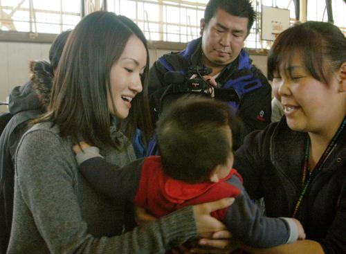 避難所を訪問し赤ちゃんを抱く、フィギュアスケート五輪金メダリストの荒川静香さん（左）