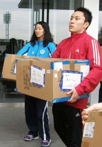 東日本大震災の被災者のため、支援物資の荷出しを手伝うフェンシングの太田雄貴選手（右）ら