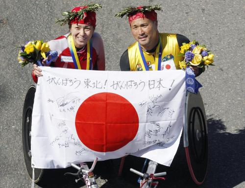 ボストン・マラソンの車いすの部で優勝し、日の丸を掲げる女子の土田和歌子（左）、男子の副島正純両選手
