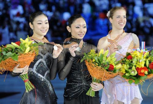 フィギュアスケートの世界選手権で４年ぶり２度目の優勝を果たし、表彰式で笑顔を見せる安藤美姫。左は２位のキム・ヨナ、右は３位のカロリナ・コストナー
